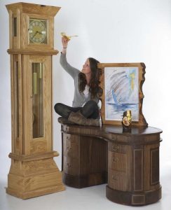 Senaid Denholm with the grand father clock, desk & mirror she made when a student