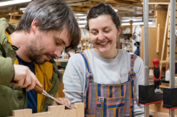 Tutor Matthew Brebner showing Marion Morris the right technique for paring down dovetails